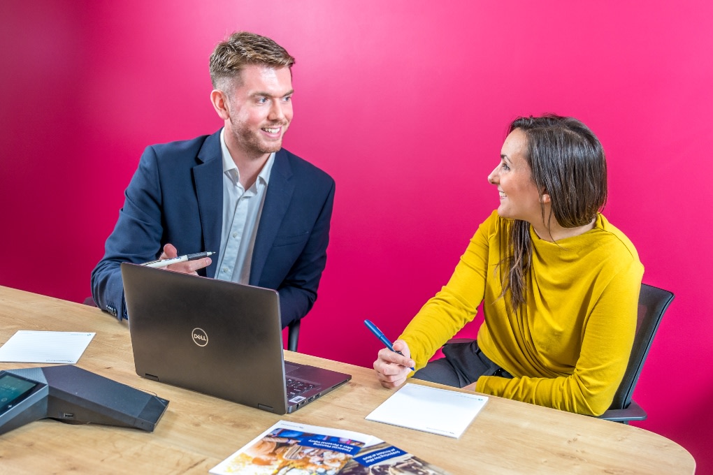 Two people working at a laptop